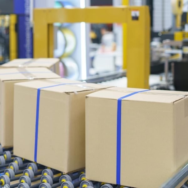 machine appears to use tape to close and seal cardboard boxes automatically